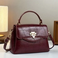 Makro-Detail der weinroten Handtasche aus Krokodilleder mit goldenem Schildschloss - Rot