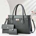 Detailed view of dark grey three-piece handbag set with textured weave and gold hardware - Gray