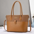 Sac fourre-tout marron bi-matière avec texture tressée et cuir lisse sur un bureau - Jaune Terre
