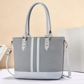 Detail van grijze tote tas met geweven textuur, leerstiksels en gouden hardware-accenten - Blauw