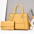 Detail of yellow tote bag set with golden studs including a matching envelope pouch - Yellow