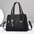 Elegante borsa a mano in pelle nera con doppi manici e ciondolo a cuore in metallo - Nero