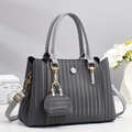 Détail d'un sac à main gris foncé avec plis verticaux et mini pochette décorative - Gris
