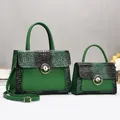 Detail of green and black crocodile texture handbag with gold metal lock hardware - Green