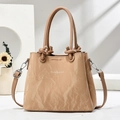 Detail der beigen Handtasche aus Kunstleder mit Wellenstruktur und Knotengriffen - Khaki