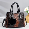 Detail of gradient brown crocodile embossed tote bag with glossy finish and round pendant - Brown