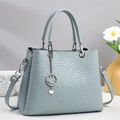 Detailed view of woven texture and silver smile pendant on light blue tote bag - Blue