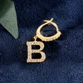 Goldene Huggie-Ohrringe mit einem funkelnden, zirkoniabesetzten Buchstaben-B-Anhänger - B Gold