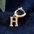 Luxuriöse 18K Gold Creolen mit Buchstabe H und Zirkonbesatz auf blauem Samt - Gold H
