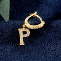 Gouden oorring met letter P-bedeltje en zirkonia op een donkerblauwe fluwelen achtergrond - Letter P Goud