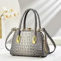 Detail of grey crocodile pattern evening bag with crystal clasp and gold handle - Gray
