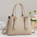 Sac à main beige texturé avec double poignée et bandoulière amovible sur une table - Abricot