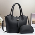 Macro detail of black lychee grain leather tote bag set with golden hardware and accessories - Black
