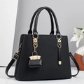 Borsa a mano nera a righe con dettagli dorati e mini ciondolo in esposizione studio - Nero