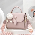 Dettaglio borsa in pelle martellata con fibbia in metallo, tracolla e ciondolo pompon - Rosa