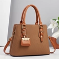 Detail of tan woven texture handbag with gold hardware and mini bag charm accessory - Khaki/Earth Yellow