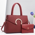 Macro detail of wine red PU leather texture and gold horseshoe clasp on shoulder bag - Red