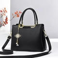 Black lychee pattern leather tote bag with gold knot pendant and adjustable shoulder strap - Black
