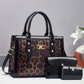 Dettaglio della borsa leopardata in pelle verniciata nera con logo in metallo dorato - caffè