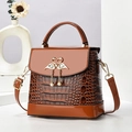 Brown crocodile pattern mini handbag with golden flamingo buckle and pearl detail - Earthy Yellow