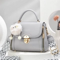 Sac à main gris en cuir grainé avec bandoulière géométrique et fermoir doré sur socle blanc - Gris