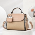 Elegant tan woven handbag with smooth leather flap and adjustable strap on a stone pedestal - Khaki