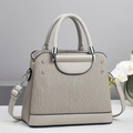 Gros plan des textures ondulées verticales et détails argentés sur un sac à main gris beige - L25 L11 H21 / Gris