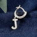 Silberner J-Buchstaben Ohrring mit funkelnden Zirkonia auf einem dunkelblauen Samthintergrund - Buchstabe J Platin