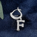 Silberfarbener Ohrring mit Zirkonia-besetztem Anhänger Buchstabe F auf Samtuntergrund - Buchstabe F Platin