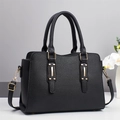 Close-up of black lychee grain handbag with gold metal buckles and adjustable strap - Black