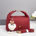 Burgundy textured tote bag with golden logo and cute white plush charm on grey background - Red