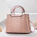 Dettaglio della borsa rosa con stampa coccodrillo, trama e anelli metallici dorati - Bianco