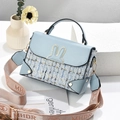 Dettaglio borsa a tracolla in tweed azzurro con orecchie di coniglio e tracolla MHDR - Celeste