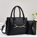 Black lychee leather tote bag with gold horsebit hardware and matching wallet on white surface - Black