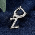 Silberner Z-Buchstaben-Ohrring mit Zirkonia-Besatz auf blauem Samthintergrund - Buchstabe Z Platin