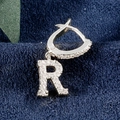 Silberne Creolen mit Buchstaben R und Zirkonia auf blauem Samthintergrund - Buchstabe R Platin