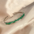 Silver bangle with emerald cut green zircon stones in a stacked irregular geometric design - Green