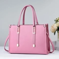 Detalle de bolso rosa claro con textura de grano y adornos metálicos dorados - Rosa
