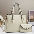Close-up of litchi grain cream tote bag and matching envelope pouch with gold hardware - Off-white