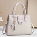 Detail of lychee pattern leather tote with star charm and metallic circular twist lock - Gray