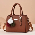 Brown litchi grain leather handbag with gold hardware and colorful pompom charm - Earthy Yellow