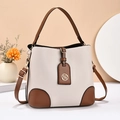 Minimalistische weiße Eimertasche aus Leder mit braunen Details und Goldbeschlägen - Gebrochenes Weiß