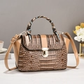 Dettaglio borsa a tracolla kaki con texture coccodrillo, manico foulard e chiusura a U - Cachi