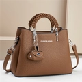 Detail of lychee pattern leather handbag with woven handle and silver metal hardware - Brown