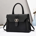 Vintage zwarte crossbodytas met geweven textuur en gouden gesp in een lifestyle-omgeving - Zwart