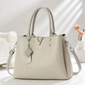 Elegant beige embossed leather handbag with V-shaped metal logo and adjustable strap - Light Gray