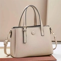 Dettaglio borsa beige in pelle a grana di litchi con fibbie dorate e trama elegante - Albicocca