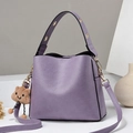 Chic light purple bucket bag with wide gold eyelet strap and plush cloud charm - Purple