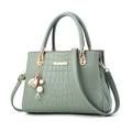 Elegant mint green handbag with crocodile texture and decorative floral bag charm - Green