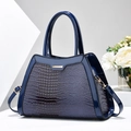 Detail of dark blue faux crocodile leather handbag with glossy finish and gold hardware - Blue